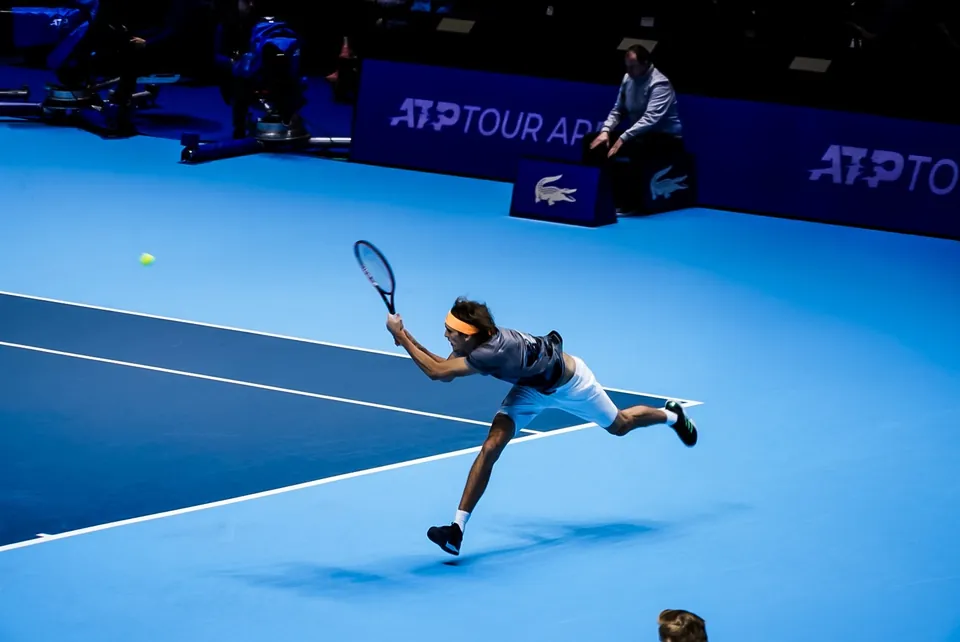 Alexander Zverev streckt sich zum Rückhand-Return auf dem blauen Hallenplatz der ATP Finals 2019 in London
