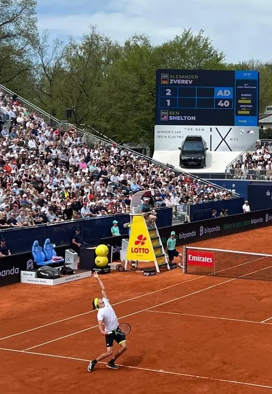 Alexander Zverev beim Aufschlag vor voller Tribüne, auf der Anzeigetafel Zverev gegen Shelton, München 2025