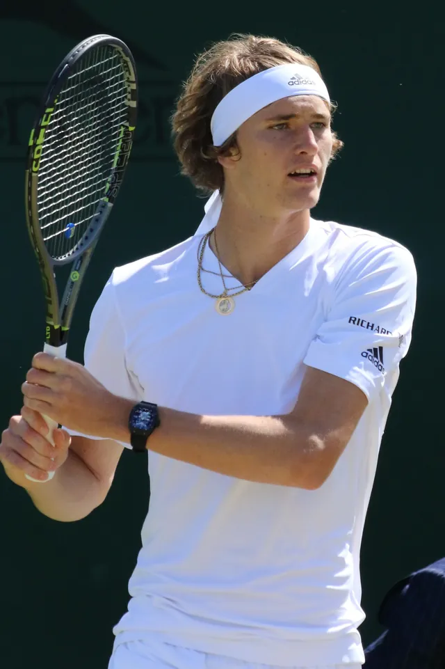 Alexander Zverev in Weiß mit Stirnband und Schläger in beiden Händen in Wimbledon 2016